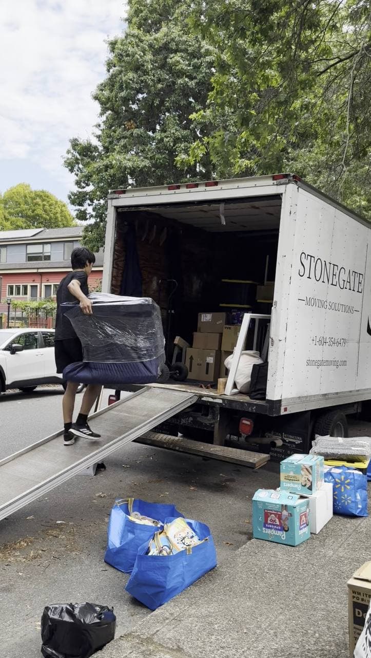 Stonegate mover carrying wrapped furniture down the truck ramp during a Burnaby apartment move