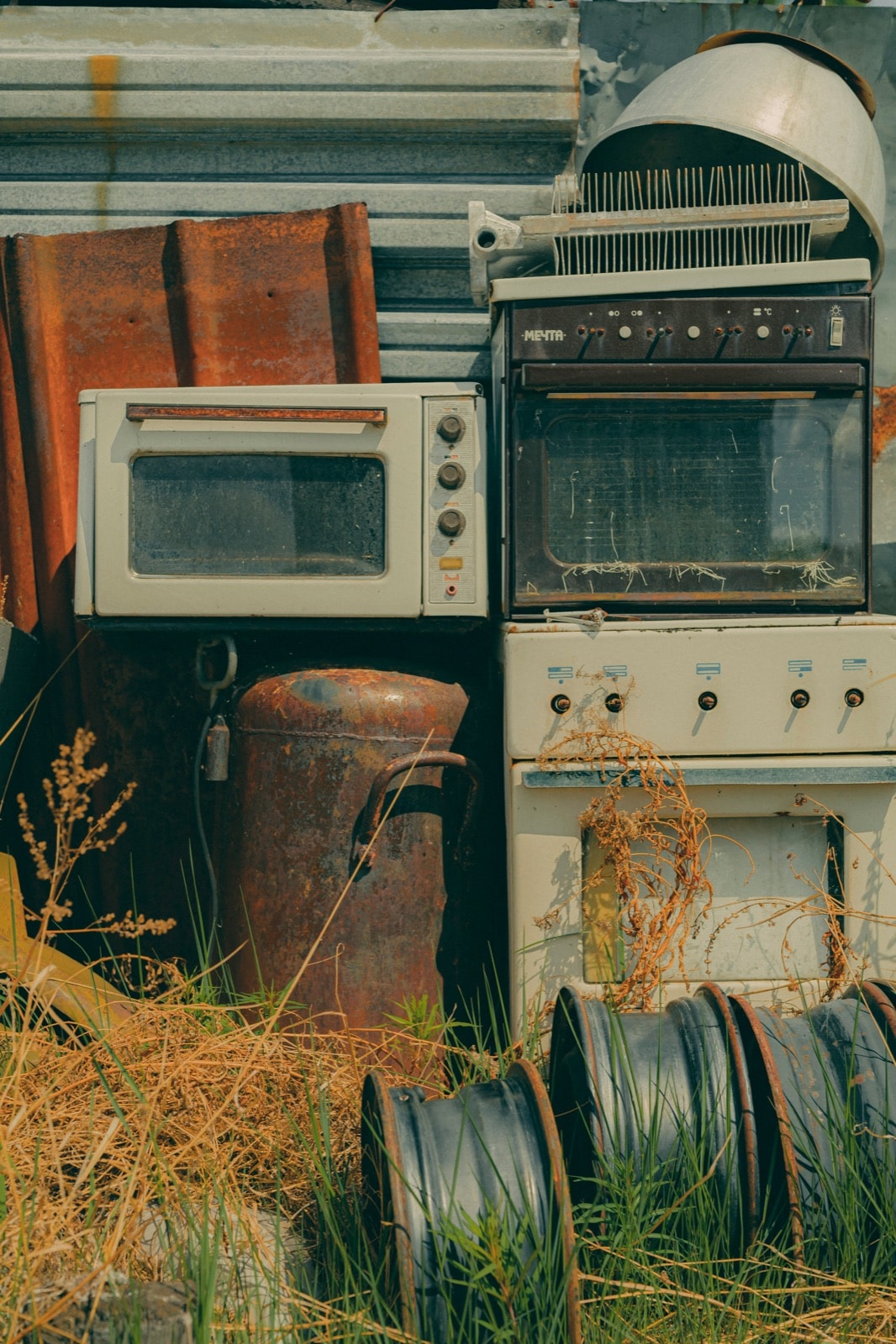 Old stoves, ovens and a water tank waiting for appliance removal