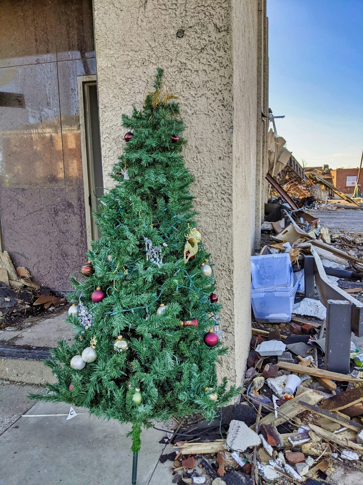 Decorated artificial Christmas tree left outside, waiting for Christmas tree removal