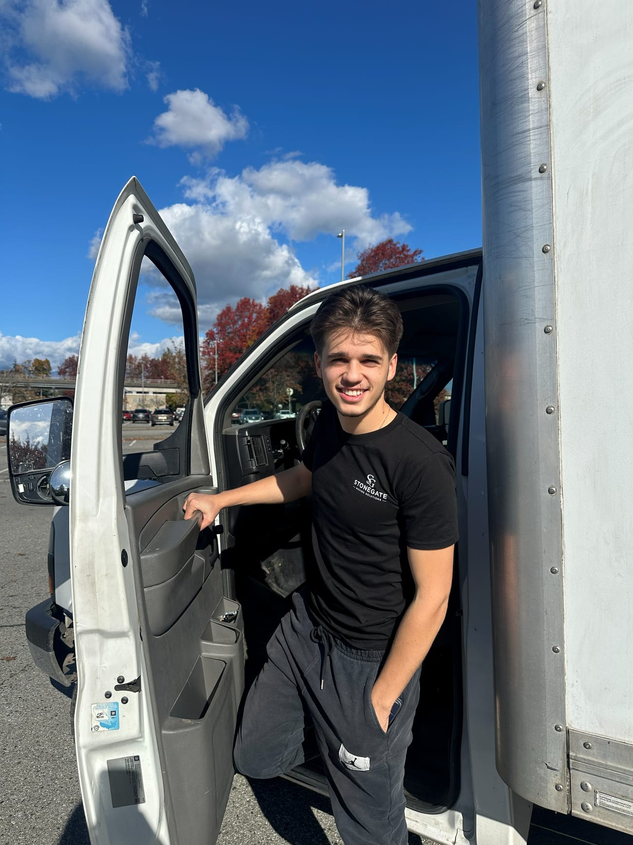 Friendly Stonegate driver stepping out of the junk removal truck cab