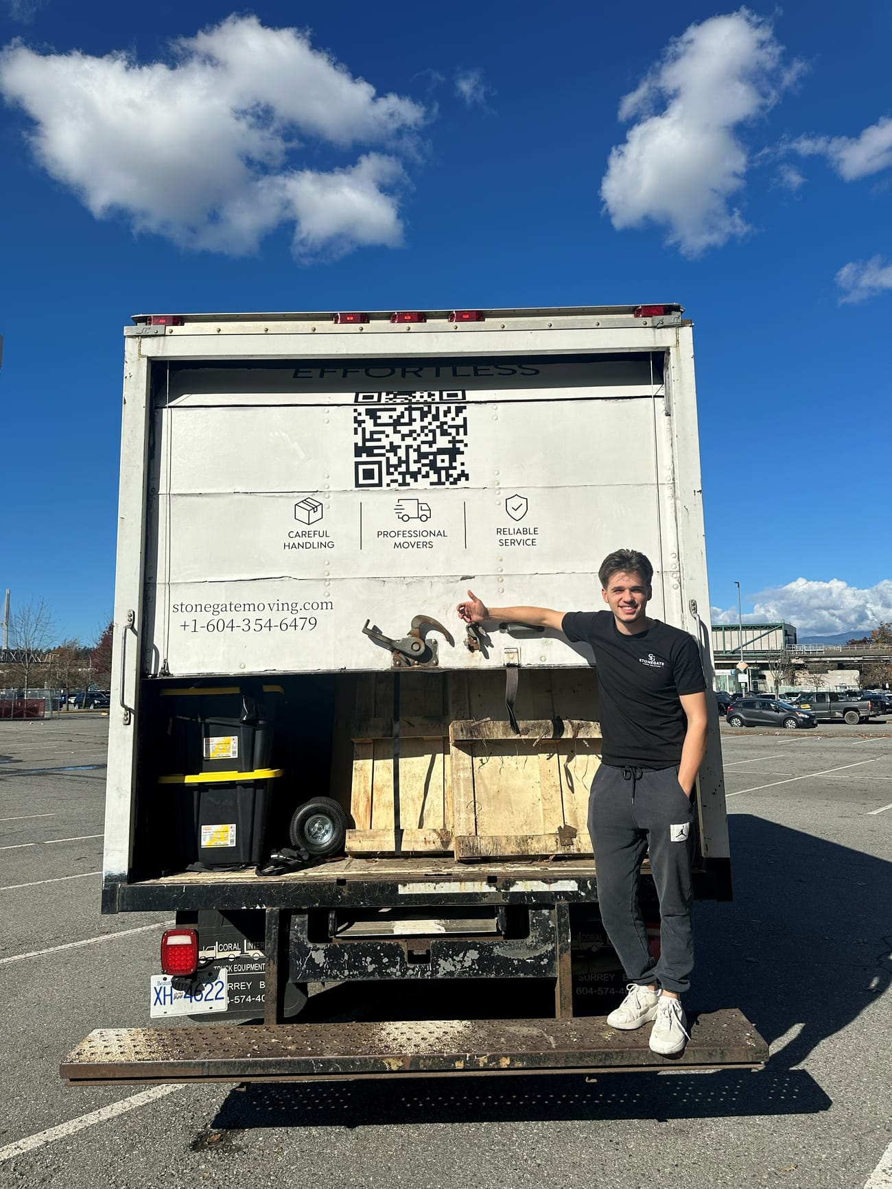 Stonegate crew member on the tailgate of the branded Stonegate truck