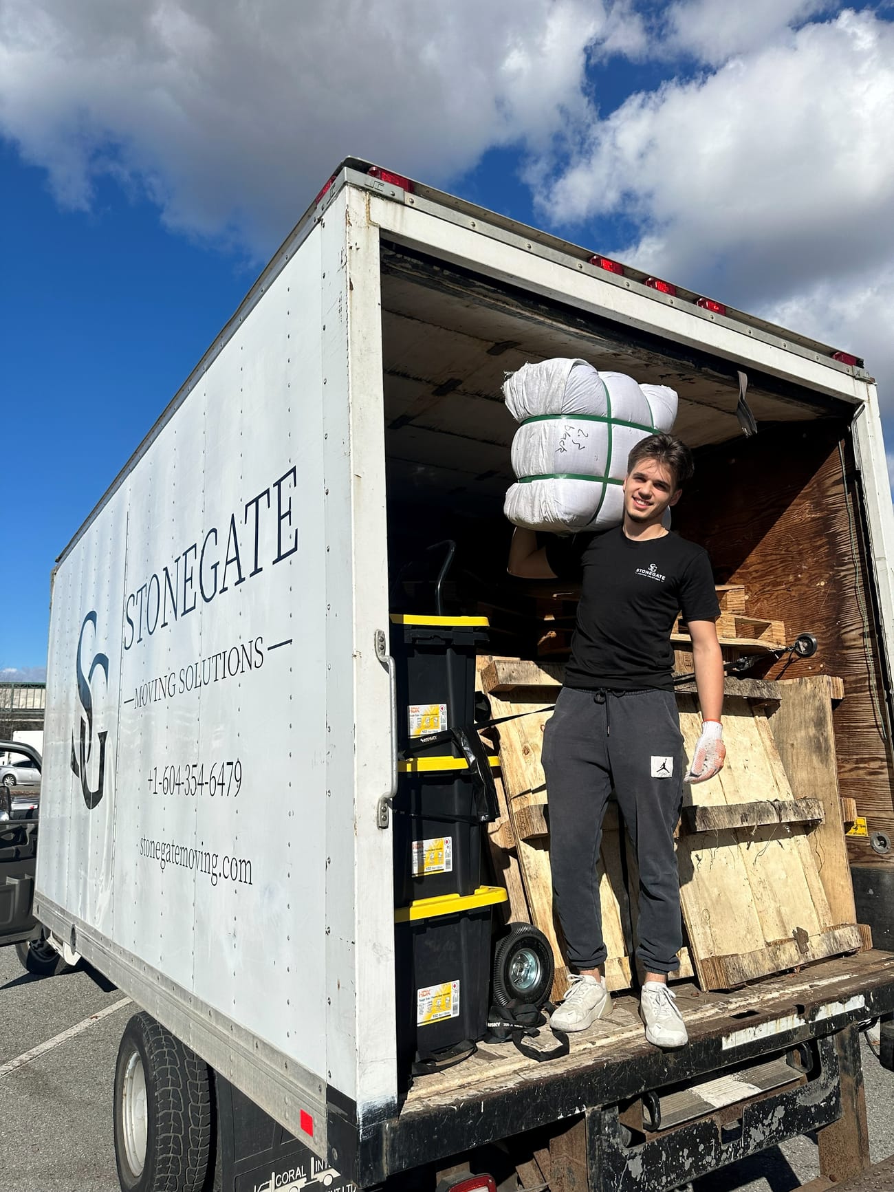Stonegate crew member standing in the back of a fully loaded Stonegate truck