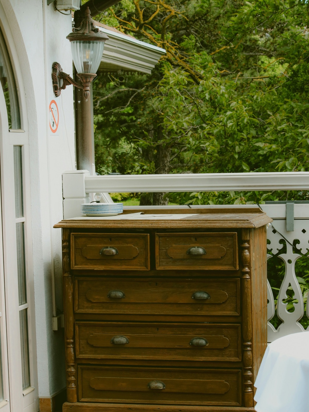 Old solid-wood chest of drawers on a porch, ready for dresser removal