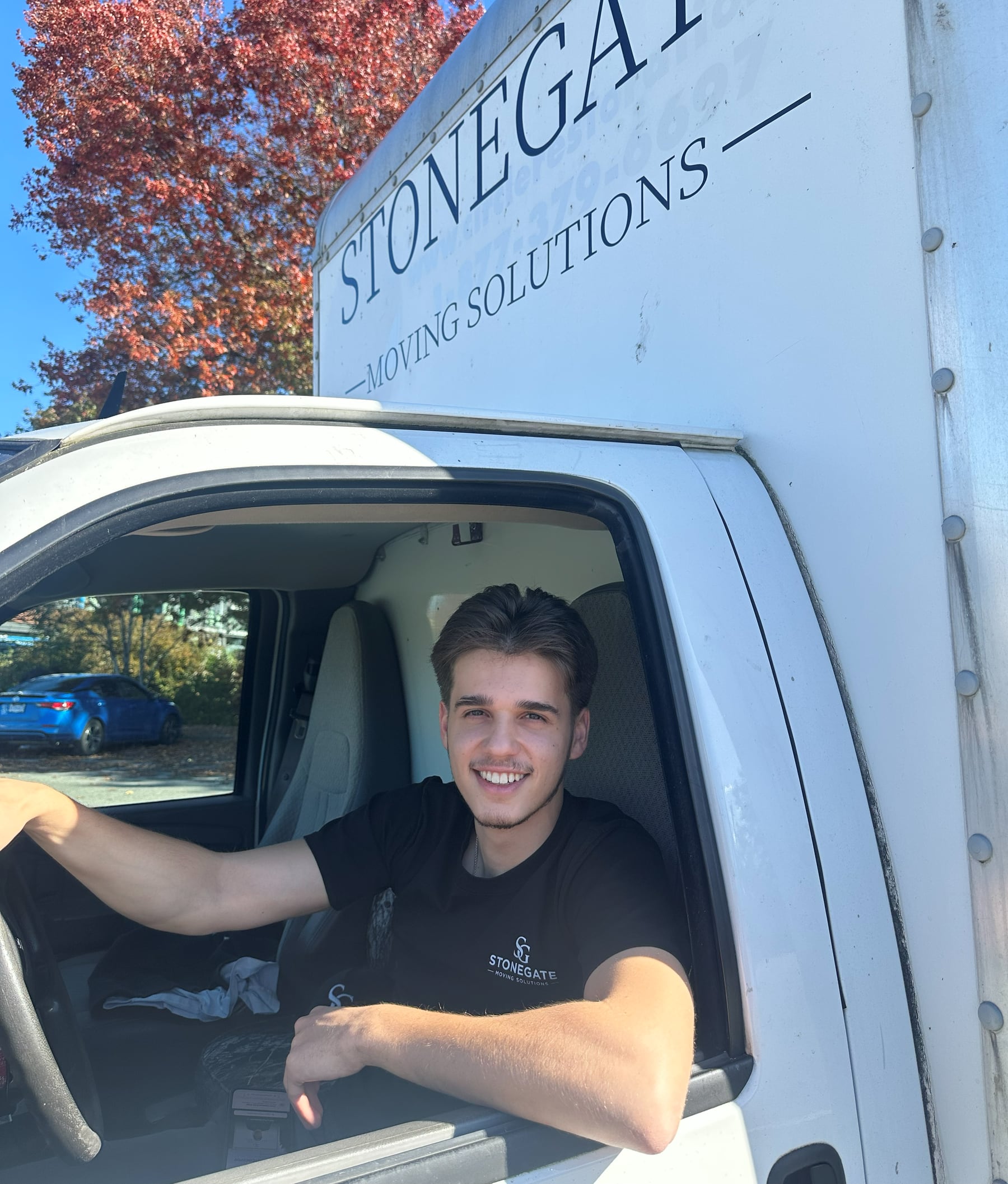 Smiling Stonegate driver in the cab of the junk removal truck