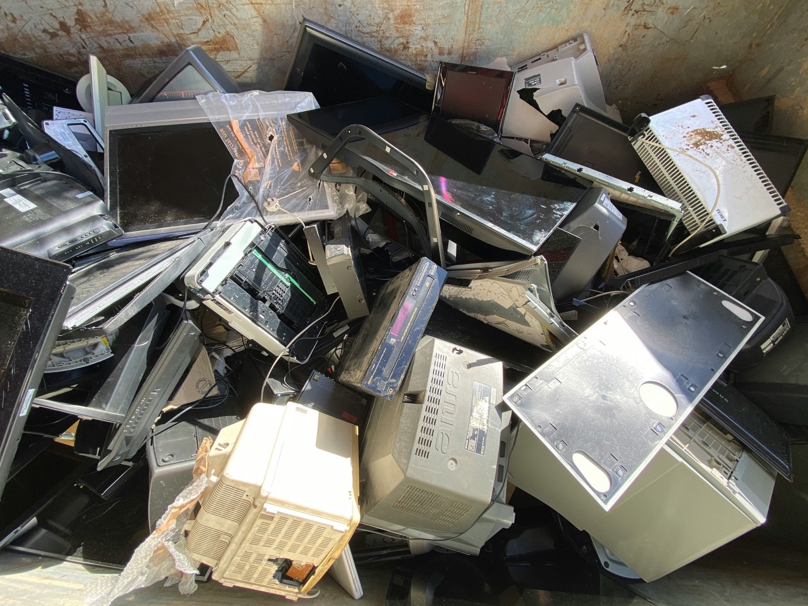 Pile of old monitors, printers, computers and cables collected during e-waste removal