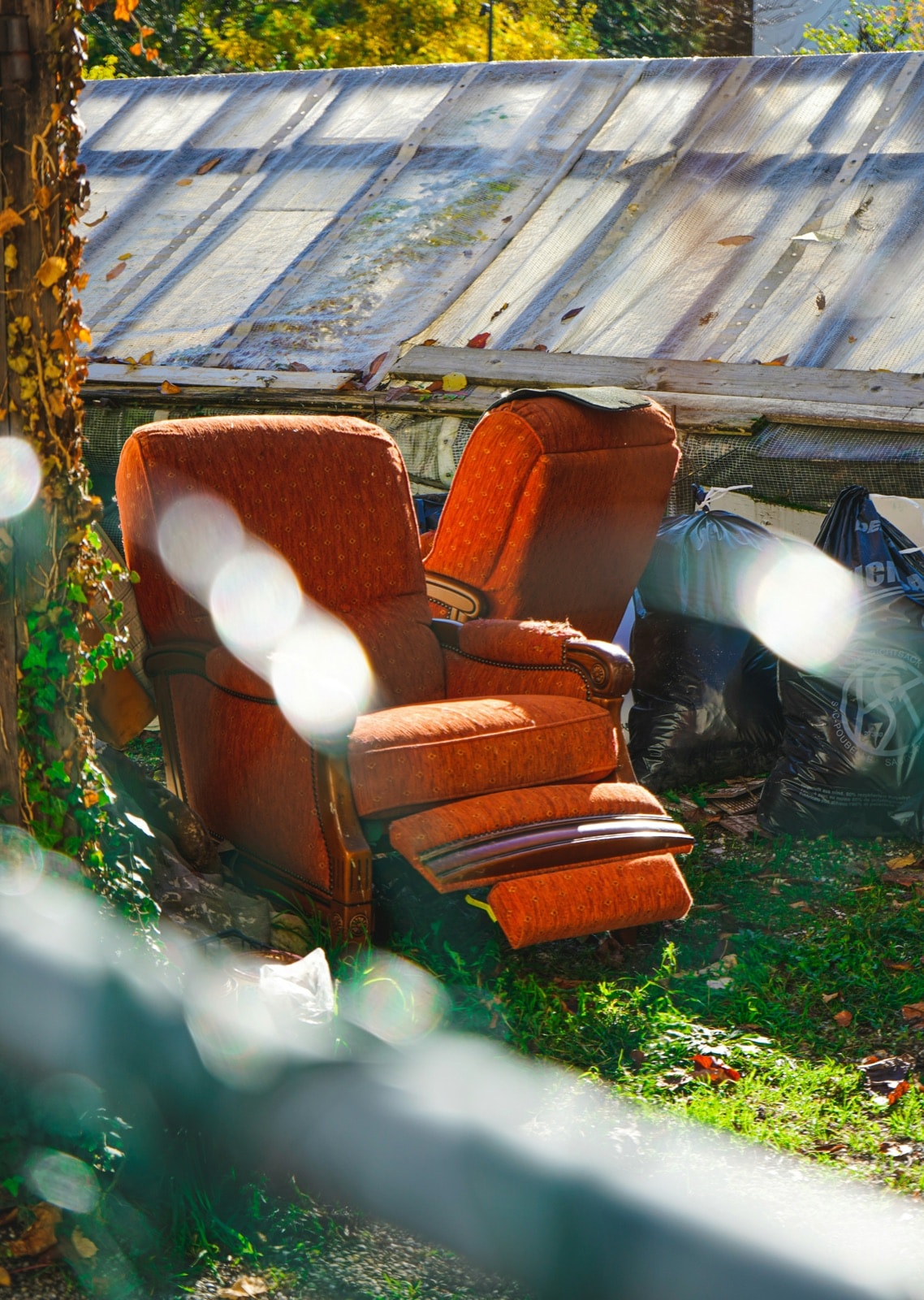 Two worn recliners left outside, waiting for furniture removal