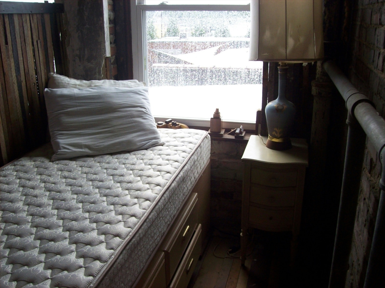 Old mattress on a bed frame, ready for mattress removal