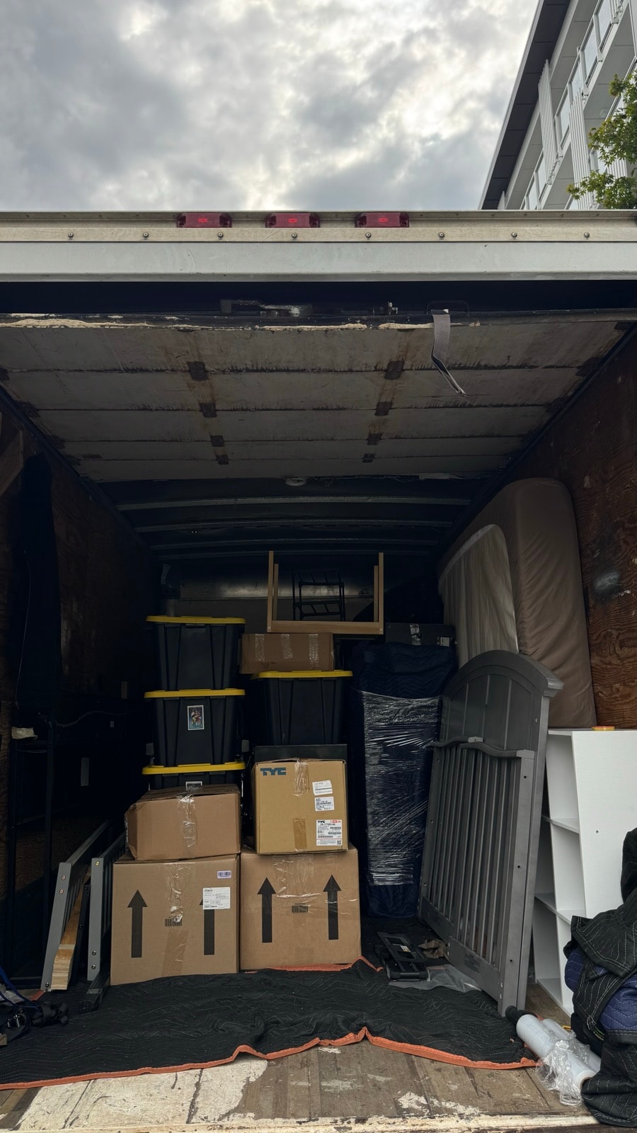 Stonegate truck loaded with boxes, bins and furniture outside a condo building on move-out day