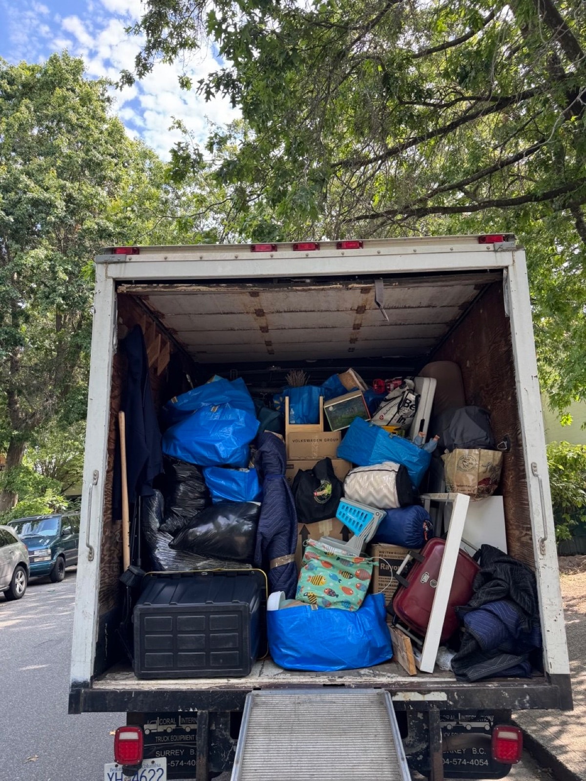 Stonegate truck packed with bags, bins, luggage and household items from a residential junk removal job