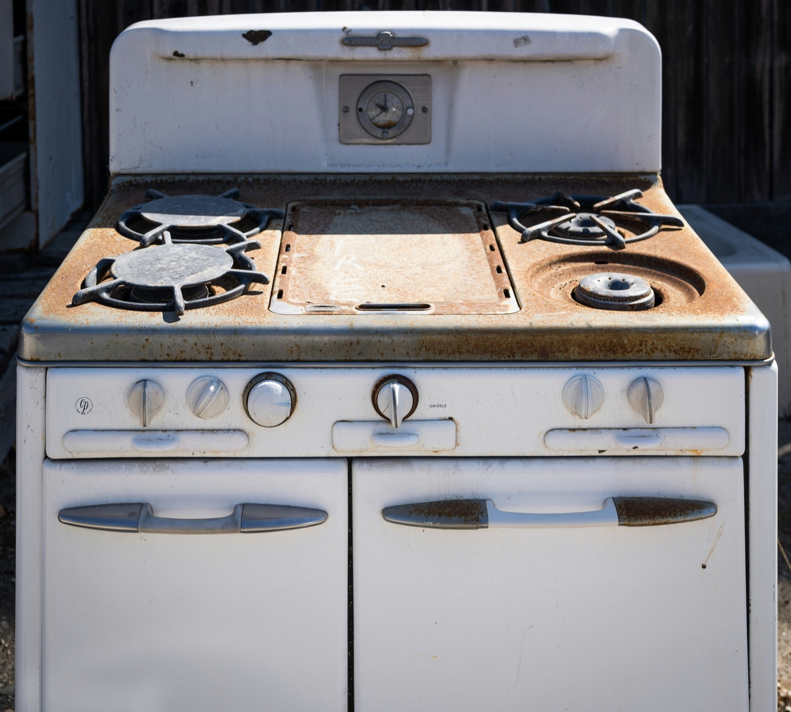 Rusted old gas stove and oven waiting for stove removal