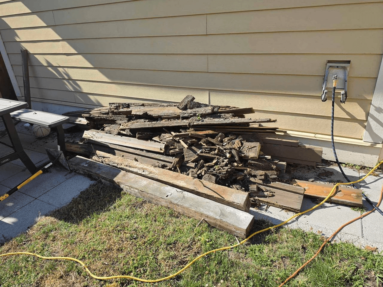 Renovation debris and old lumber piled beside a house