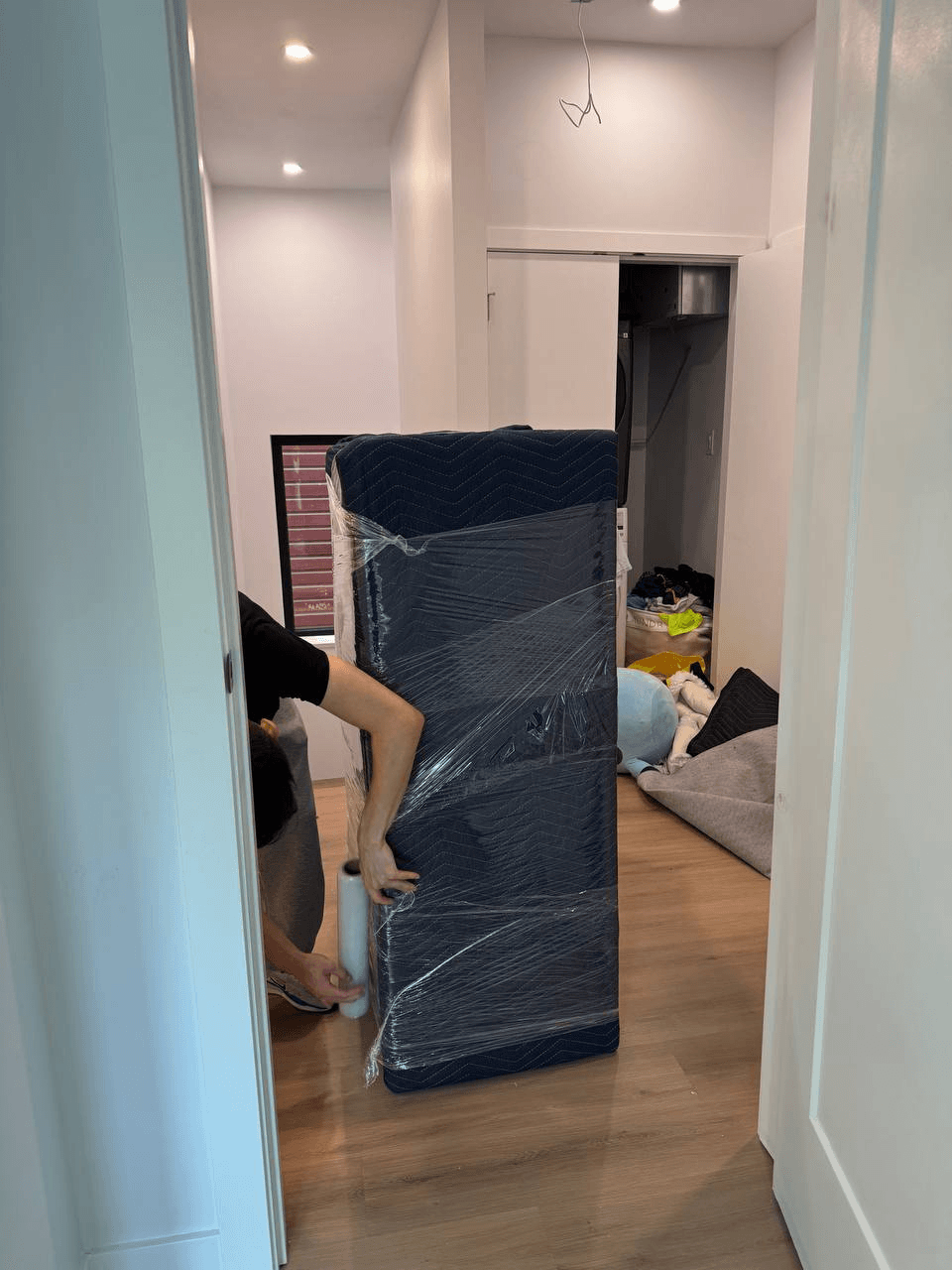 Stonegate mover wrapping furniture in a moving blanket during a move in Anmore
