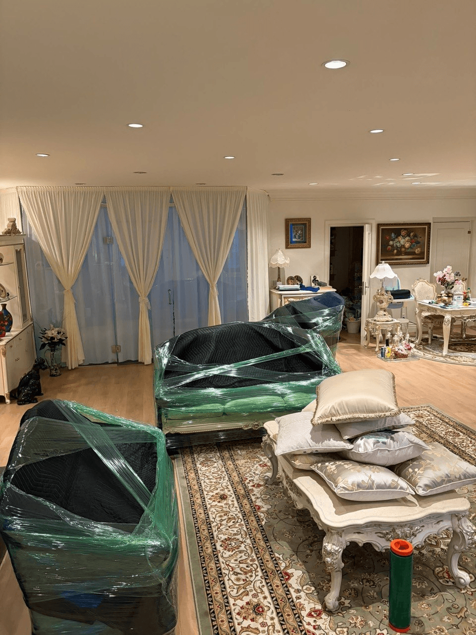 Blanket-wrapped sofas placed in the living room of the new home, ready to unwrap
